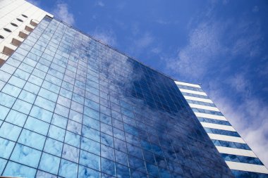Modern ofis binasının camlarına yansıyan bulutlar