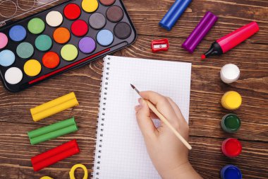 Boş defter, okul malzemeleri ahşap Resepsiyon arka plan üzerinde brushwith çerçevesinde eliyle açıldı. Geri okul kavramı.