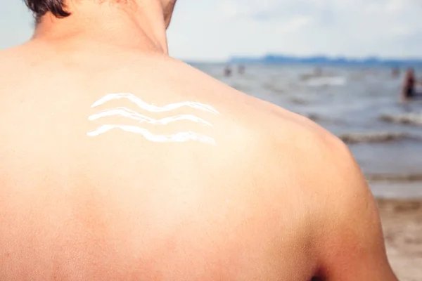 Lotion man with sunscreen sea waves on the sea background