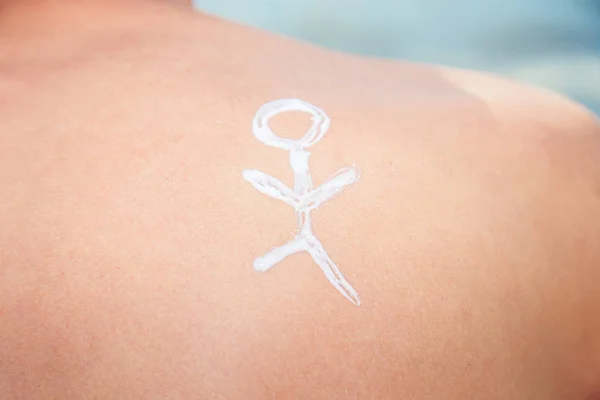 Man van de lotion met zonnebrandcrème met een mannetje op de pagina van de zee — Stockfoto