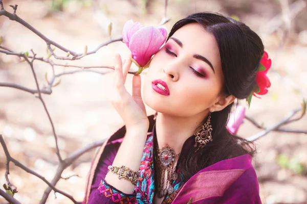 Mooie jonge Aziatische vrouw die geniet van de geur van magnolia bloss — Stockfoto