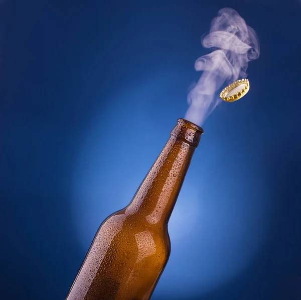 Hand opens a bottle of cold beer — Stock Photo, Image
