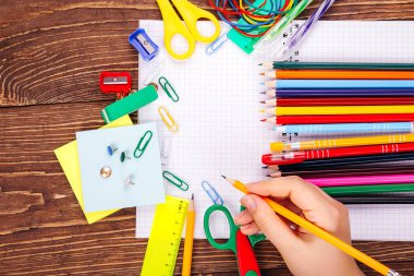 Boş defter, okul malzemeleri ahşap Resepsiyon arka plan üzerinde brushwith çerçevesinde eliyle açıldı. Kopya alanı ile başa okul kavramı.