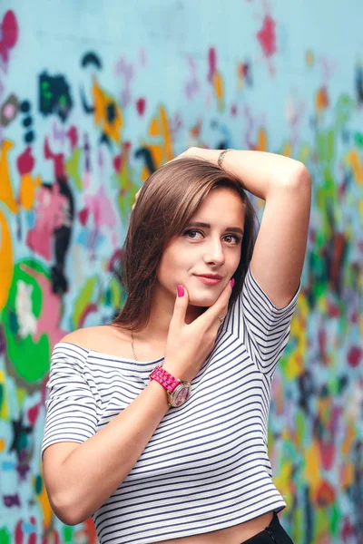 Vrolijke jonge vrouw die zich voordeed op een achtergrond van lichte muren — Stockfoto