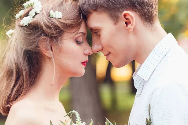 Gelukkig jonge jonggehuwde paar touching voorhoofd en neus in park — Stockfoto