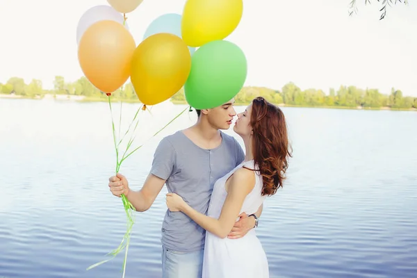 Adorável feliz casal feliz com balões, olhando um para o outro um — Fotografia de Stock