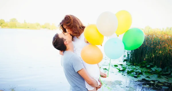 Belo Casal Feliz Com Balões Beijando Perto Rio Ele Segurando — Fotografia de Stock