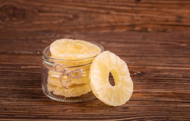 Ahşap arka plan üzerinde bir kavanoza şekerlenmiş ananas