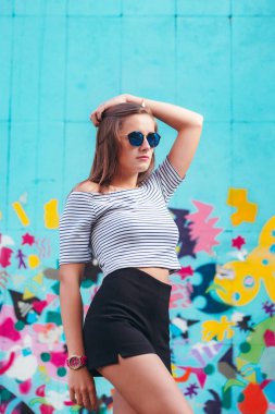 yuvarlak gözlük parlak duvarlar arka plan üzerinde poz ile neşeli genç kadın