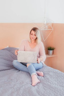 Şoförünün yatakta oturup bir dizüstü bilgisayar üzerinde çalışan mutlu rahat güzel kadın