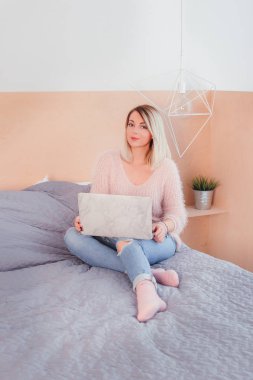 Şoförünün yatakta oturup bir dizüstü bilgisayar üzerinde çalışan mutlu rahat güzel kadın