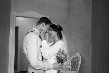 Gelin ve damat yatak odasında toplantı, yeni evlilere mutluluk duyarız. Elinde çiçek olan adam. Seviyorum. Kucaklama. Siyah ve beyaz.