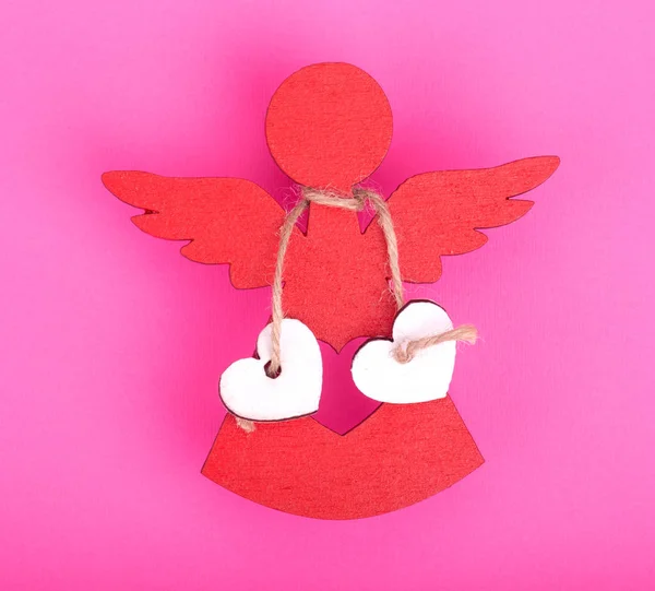 红色天使的圣诞节装饰品与两个链接白色的心在粉红色的背景 — 图库照片