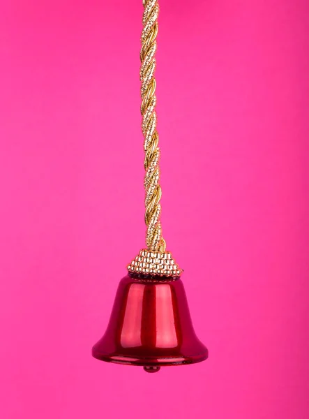 ピンクの背景のクリスマス飾り つ赤い鐘 — ストック写真
