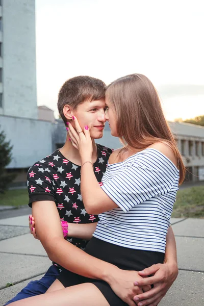 Namorado abraçando sua namorada, ela estava sentada em suas mãos — Fotografia de Stock