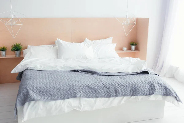 Interior del dormitorio con cama gris claro y paredes blancas —  Fotos de Stock