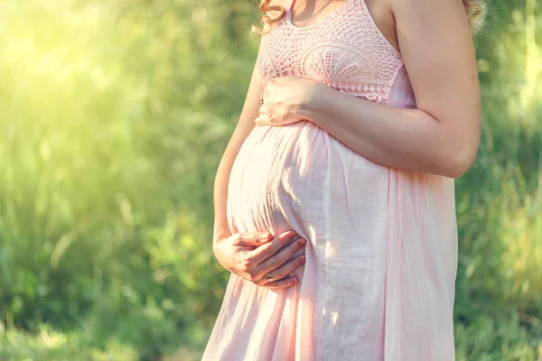 Pregnant lovely woman in pink dress — Stock Photo, Image