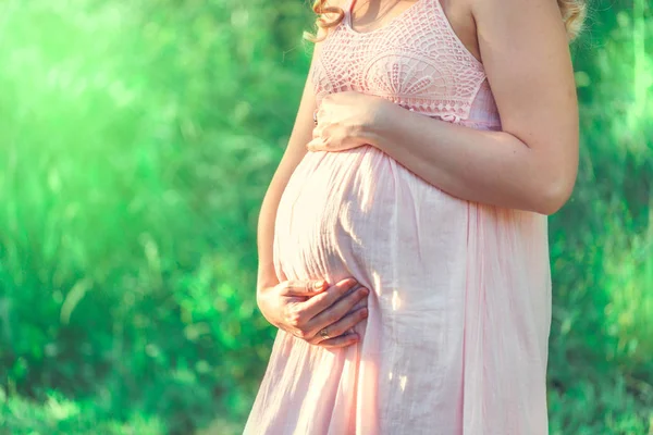 Mulher encantadora grávida em vestido rosa — Fotografia de Stock