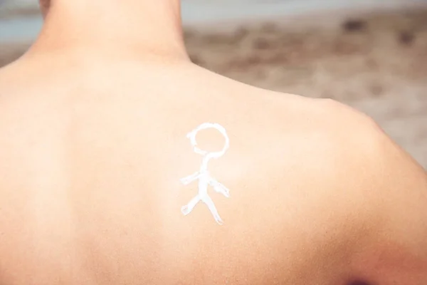 Lotion man with sunscreen with a little man on the sea backgroun — Stock Photo, Image