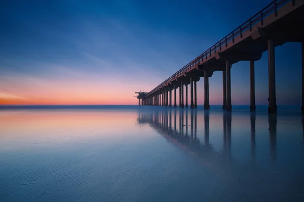 ブリッジと夕日の終わり穏やかな海の風景 ロイヤリティフリーのストック写真