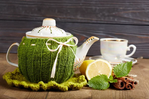 Teapot with handmade knitted cover, lemon, cinnamon, mint — Stock Photo, Image