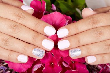 Ellerini beyaz oje ile renkli kısa manikürlü tırnaklar 