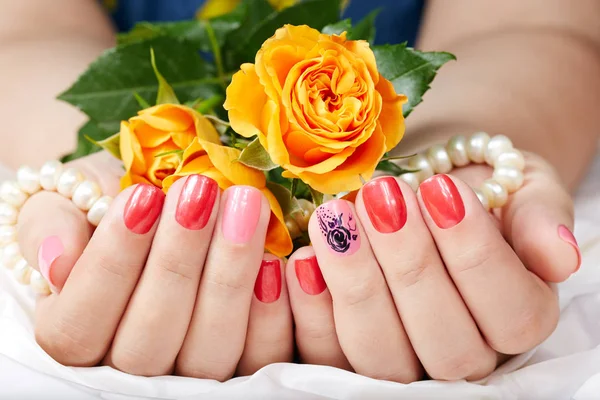 Ręce z krótkim wypielęgnowane paznokcie kolorowe z różowy i czerwony lakier do paznokci — Zdjęcie stockowe