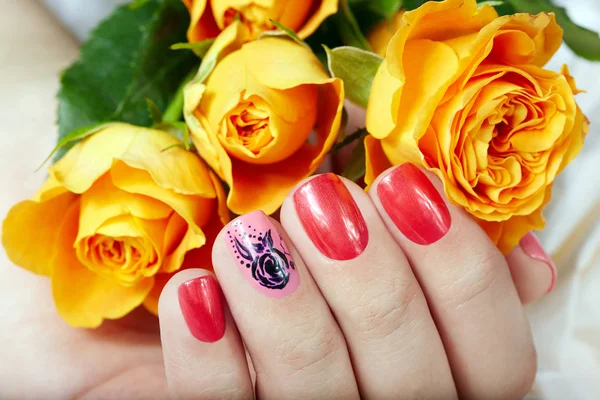 Hand med korta manikyrerade naglar färgat med rosa och röda nagellack — Stockfoto