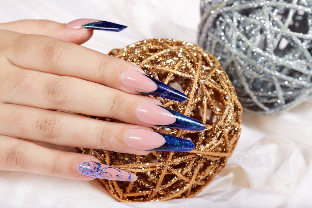 Hand with beautiful long artificial blue french manicured nails