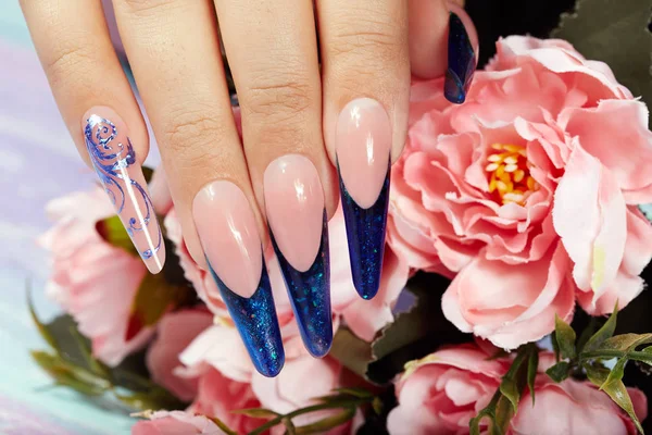 長い人工ブルー手フランス手入れされた爪とピンクのバラの花 — ストック写真