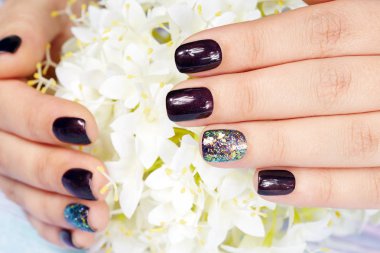 Elleri manikürlü tırnaklar ile koyu mor oje renkli 