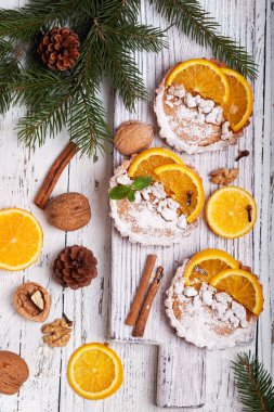 Portakallı mini tart turtaları, krema ve ahşap arka planda ceviz. Tatlı Noel tatlısı. 