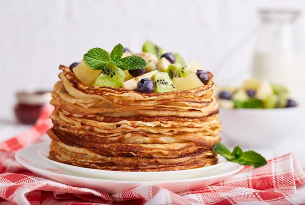 Thin crepe pancakes with fruits and berries. Traditional Russian cuisine. Crepe week. Maslenitsa.