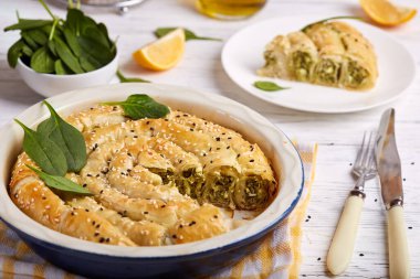Ispanaklı ve peynirli lezzetli turta, fileto pastasından yapılmış, susam tohumlarıyla süslenmiş. Geleneksel Yunan turtası spanakopita rulo şeklinde.