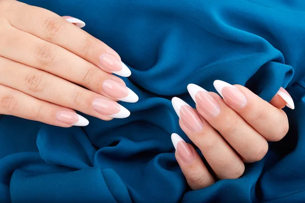 Mani Con Lunghe Unghie Artificiali Francesi Curate Sfondo Tessile Blu — Foto Stock