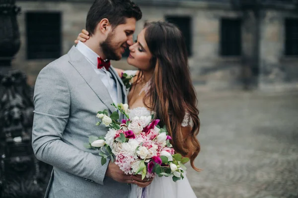 Schöne Braut und Bräutigam umarmen und küssen sich am Hochzeitstag im Freien — Stockfoto