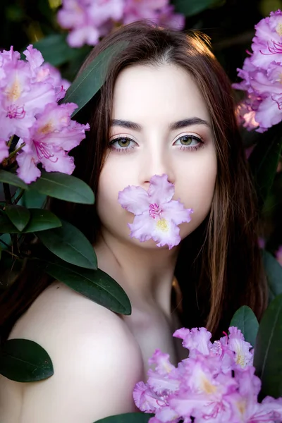 Una hermosa joven se encuentra entre los árboles florecientes. Flores de lila . — Foto de Stock