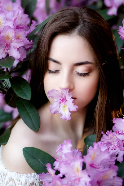 Una hermosa joven se encuentra entre los árboles florecientes. Flores de lila . — Foto de Stock