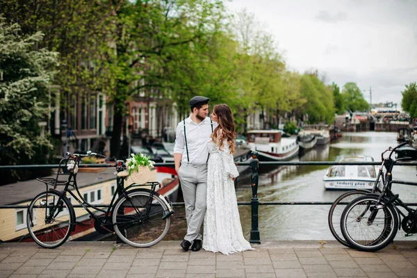 Két szerelmes ember áll egy hídon Amszterdamban. . — Stock Fotó