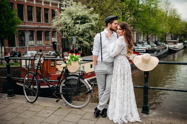 Gyönyörű férfi és nő ölelés és csók a háttérben a régi város. — Stock Fotó