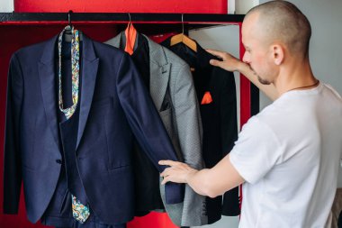 Zor seçimler karşısında. Bir erkek hangi resmi kostümü giyeceğine karar verir..