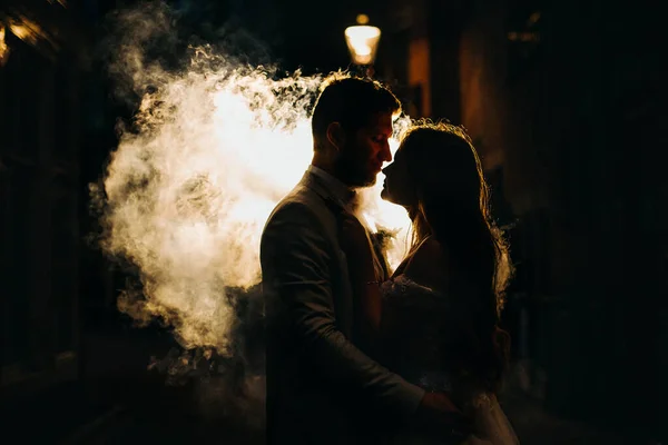 Mannen och kvinnan kysser på gatan på en rök bakgrund. — Stockfoto