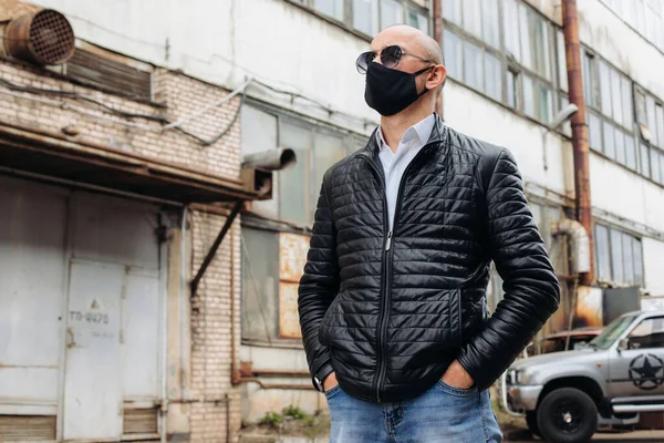 The man wears a black protective mask.The mask prevents corona virus and air pollution by dust.New type of coronavirus 2019-pneumonia nCoV masked Man