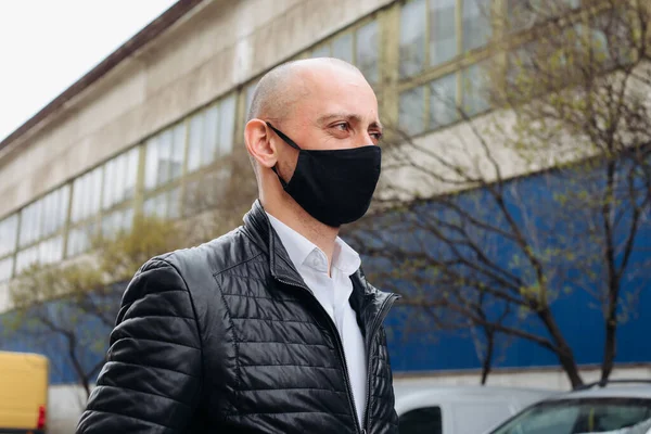 The man wears a black protective mask.The mask prevents corona virus and air pollution by dust.New type of coronavirus 2019-pneumonia nCoV masked Man
