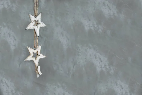 ガーランドリネン糸で明るい背景に木製の星のペンダント 灰色の背景に小さな木製の星 インテリアのための主題 テキストのためのスペース — ストック写真