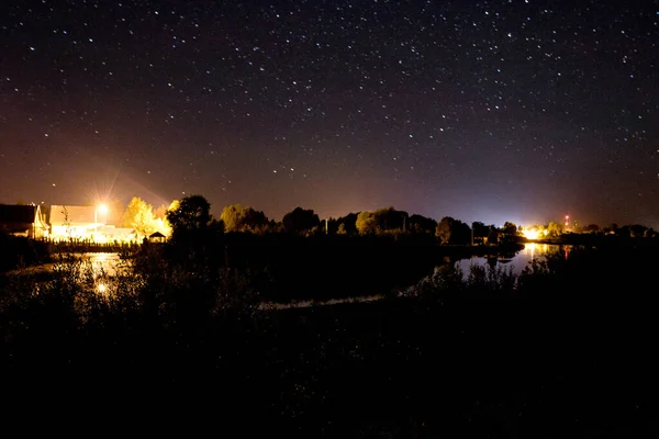 amazing panorama of the stars of the night sky with the Milky Way over the village. starry sky. night shooting.