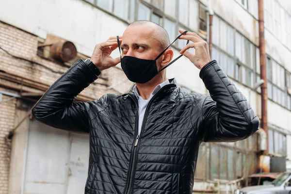 The man wears a black protective mask.The mask prevents corona virus and air pollution by dust.New type of coronavirus 2019-pneumonia nCoV masked Man