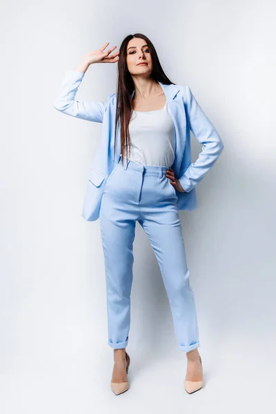 an Indian business woman with a straight hairstyle in a formal blue pantsuit, beige high-heeled shoes. Smiles . full body length isolated on white background