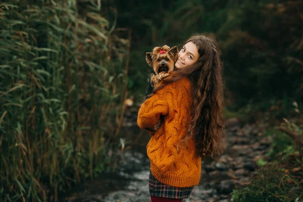 Una Ragazza Adolescente Con Capelli Ricci Lunghi Abbraccia Piccolo Cane — Foto Stock