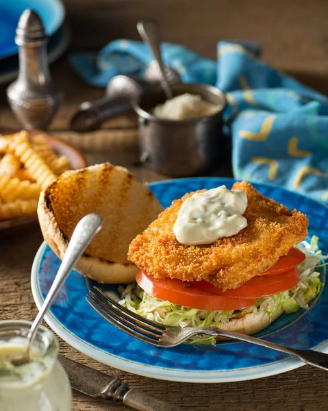 Een heerlijke huisgemaakte vis hamburger met sla, tomaat en tartaarsaus. — Stockfoto